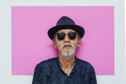 Senior asian man portrait on pink background
