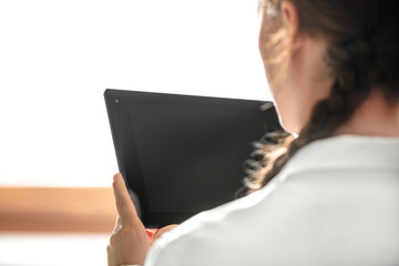 Rückenansicht einer Ärztin oder Pflegerin mit Tablet in der Hand, Textfreiraum