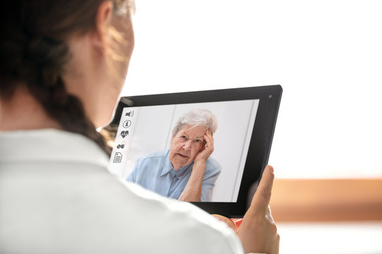 Diagnose und Sprechstunde &uuml;ber das Internet, &Auml;rztin h&auml;lt Tablet mit Patientin und Icons
