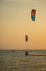 Tourists enjoy Kitesurfer surfing in the sea.