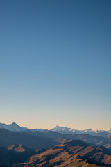 Beautiful landscape of a yellow grassland blue sky and Alps mountain at sunset.