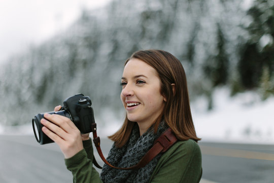 Woman Smiling and Taking Photographs with DSLR