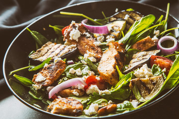 Salad with pieces grill chicken breast eggplant spinach leaves onion cheese salt and olive oil
