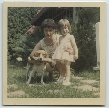 Vintage photo of young mother and toddler daughter with pet beagle  dog