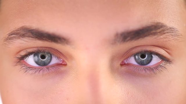 Beautiful female blue eyes closeup. Young woman eyes blinking and looking up. 4K UHD video 3840X2160