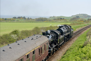 Fototapeta premium Steam engine through countryside on North Norfolk Railway 