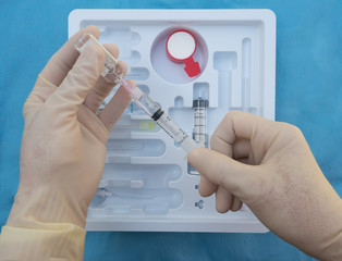 An Anesthesiologist Preparing an Injection of Local Anesthesia from a spinal anesthesia tray.