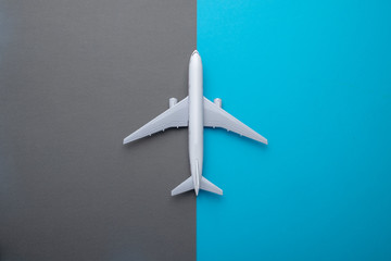 Flat lay airplane on grey and blue background