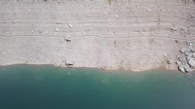 Stratifications of rocks and sand of the Lake Fregabolgia. An Alpine artificial lake. Italian Alps. Italy