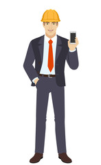 Businessman in construction helmet with hand in pocket and with mobile phone