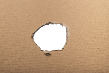 Ripped hole in brown cardboard isolated on white