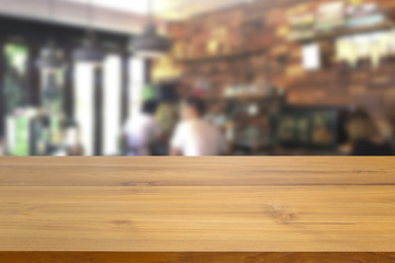 Empty wood table top and blurred people in coffee cafe background