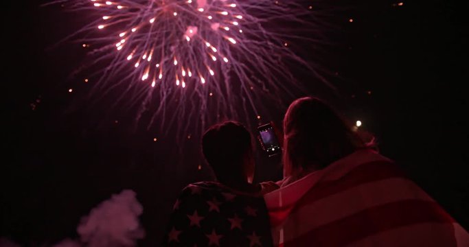 Young people taking photos of fourth of July fireworks display