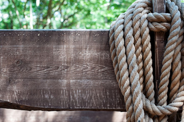 Thick rope on a background of old wooden boards in grunge style. The concept. Old American cowboy, ranch, lasso. Background for design