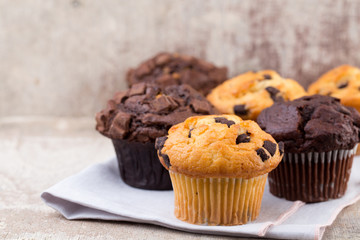 Homemade muffins with chocolate, vintage background.