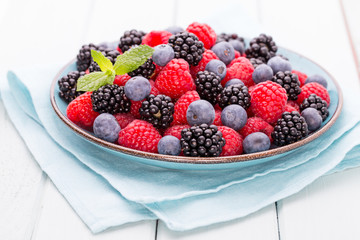 Fresh raspberries in a plate on a  vintage background.