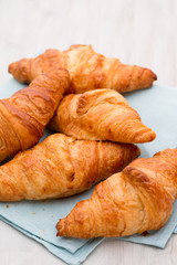 Tasty buttery croissants on old wooden table.