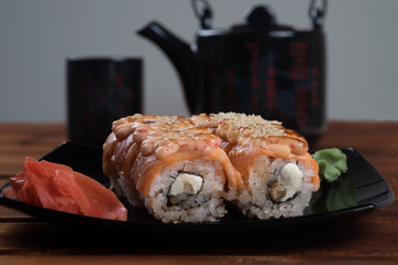 Philadelphia Sushi Roll ,California rolls with  ginger and wasabi on  black plate.