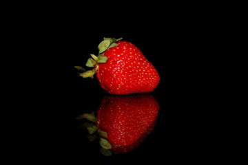 красивая красная клубника на черном фоне с отражением             