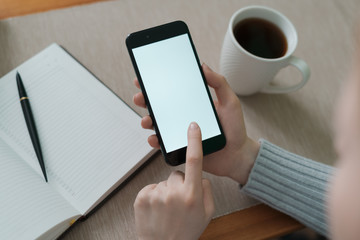 Close up notebook near smartphone with girl at cafe, out of focus photo. Concept of background learning and preparing students.