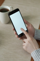 Close-up of smartphone with blank screen in female hands.