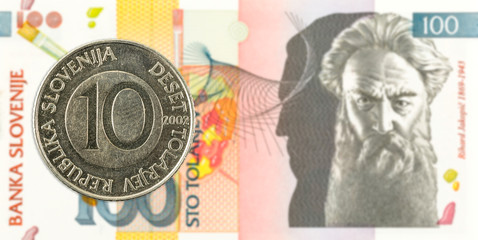 10 slovenian tolar coin against 100 slovenian tolar banknote obverse