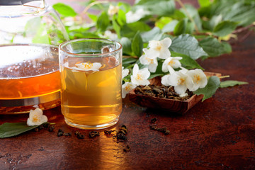 Green tea with jasmine in cup and teapot .