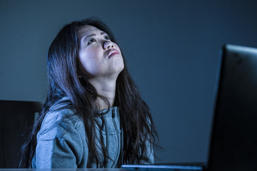 Obraz na płótnie Canvas young worried Asian Korean student girl looking depressed and desperate studying with laptop computer in stress for exam feeling frustrated