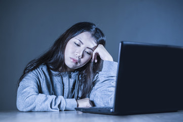 pretty sad Asian Korean student woman looking depressed and worried studying with laptop computer in stress for exam feeling bored and frustrated