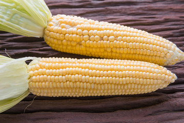 Fresh corn on cobs on rustic wooden table, closeup