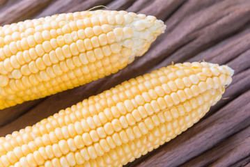 Fresh corn on cobs on rustic wooden table, closeup