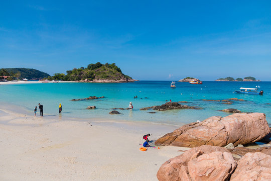 Beautiful view of Long Beach (Pasir Panjang) with its crystal clear turquoise blue water and powdery white sandy beach where tourists, adults and kids alike, are enjoying their leisure time on Redang.