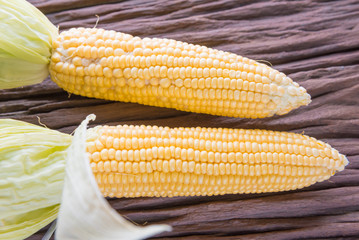 Fresh corn on cobs on rustic wooden table, closeup