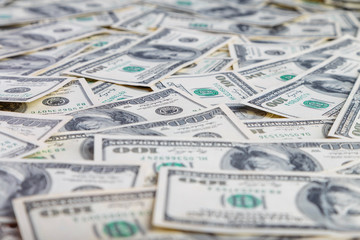 Paper 100 dollar bills spread out on the plane in a chaotic manner