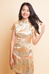 Obraz premium Portrait of Asian girl in golden chinese cheongsam dress