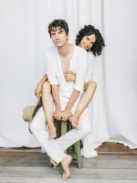 Loving people sitting on one chair
