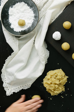 Woman rolling cookie dough into a ball to make Amaretti biscuits