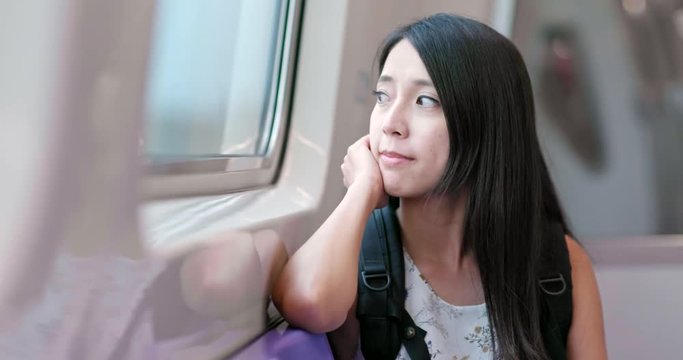 Woman taking the train and looking outside at Taipei city