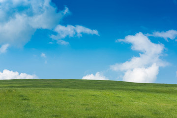 Rolling green hills and blue sky with clouds