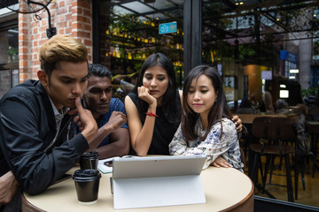 a group of asian multiculture friends discussing work at cafe