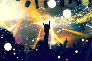 Concert crowd inside a music venue, lens flare and distress effects are visible