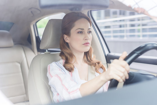 portrait of focused woman driving car alone
