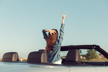 Happy traveler woman in cabrio car