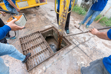 Working for drain cleaning. Problem with the drainage system.
worker with cleaning truck pumps out the dredging drain tunnel cleaning sewage in city street.