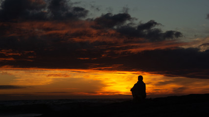 Peacefully sitting on the beach watching the sun set