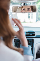 partial view of businesswoman talking on smartphone while driving car