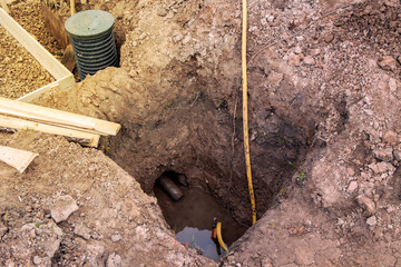 view of the construction site with trenches for the Foundation and pump pumping water for...