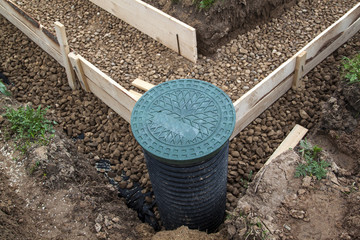 inspection well, drainage pipe and trench with formwork, which is prepared for pouring the foundation