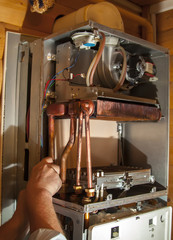 worker installs the heat exchanger after descaling on a workplac