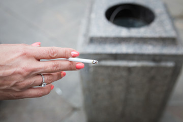 Hand of a woman with a thin cigarette closeup